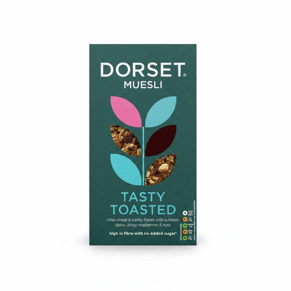 Front of a Dorset Muesli box for Tasty Toasted, showing a dark teal background with a stylized leaf logo filled with cereal pieces and product text.